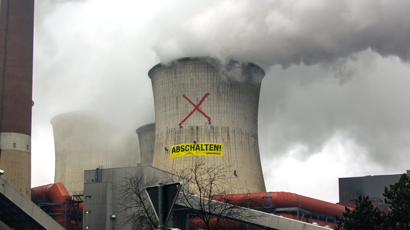 Aktivisten der Umweltschutzorganisation Greenpeace fordern das Ende des RWE-Braunkohlekraftwerks Neurath: Auch die Wissenschaftler plädieren für ein Ende der Fossilen Energiegewinnung.