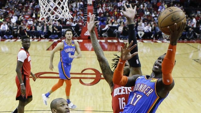 Dennis Schröder (r/17) von den Oklahoma City Thunder setzt sich am Korb gegen Ben McLemore (M) von den Houston Rockets durch. Dennis Schröder (r/17) von den Oklahoma City Thunder setzt sich am Korb gegen Ben McLemore (M) von den Houston Rockets durch.
