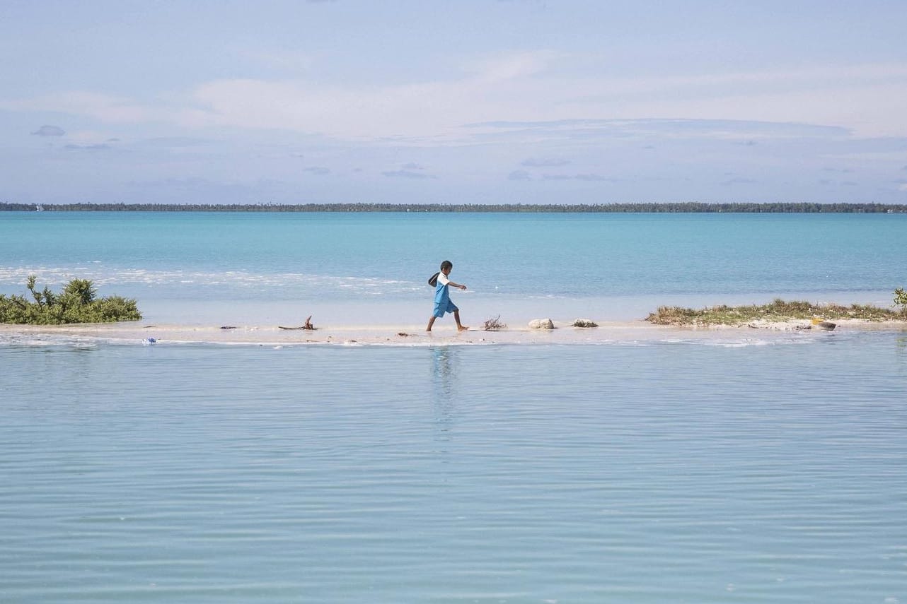 Ein Junge läuft auf Kiribati von der Schule nach Hause: Der kleine Inselstaat im Pazifik ist eines der vom Klimawandel am schlimmsten betroffenen Länder (Archivbild).