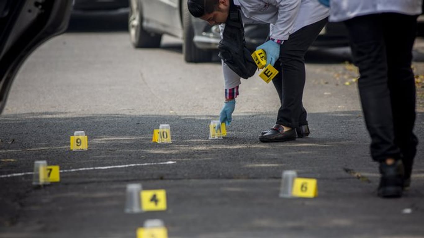 Ein forensischer Experte sammelt Beweise nach dem Tod von zwei Menschen nach einem Streit zwischen zwei kriminellen Organisationen im Norden von Mexiko-Stadt.