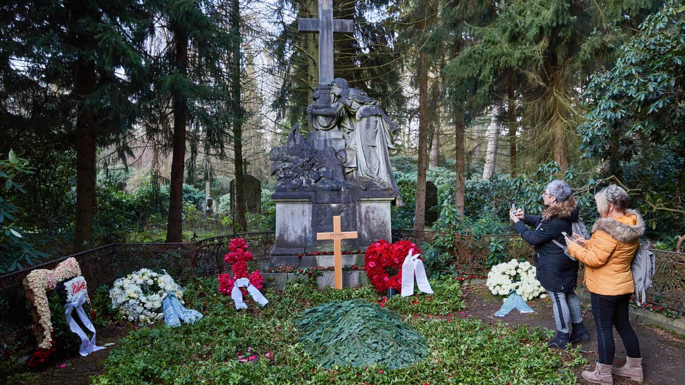 Zwei Frauen stehen am Grab von Jan Fedder: Dem Ohlsdorfer Friedhof wurde der Fanandrang zu viel.