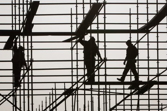 Gerüstbauer errichten in Hamburg auf einer Brückenbaustelle in der Hafencity ein Gerüst.