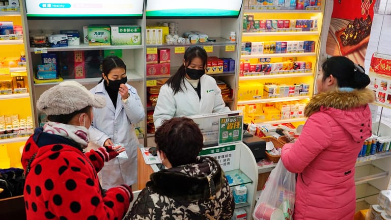 Mitarbeiterinnen verkaufen in einer Apotheke Atemschutzmasken.