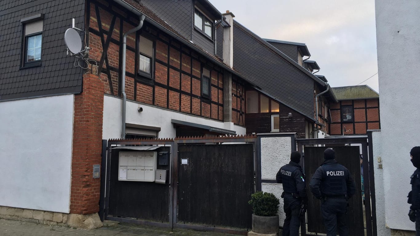 Polizisten stehen vor einem Wohnhaus in Erfurt. Neben dem Wohnhaus in Thüringen untersuchte die Polizei am Morgen weitere Objekte in insgesamt sechs Bundesländern.