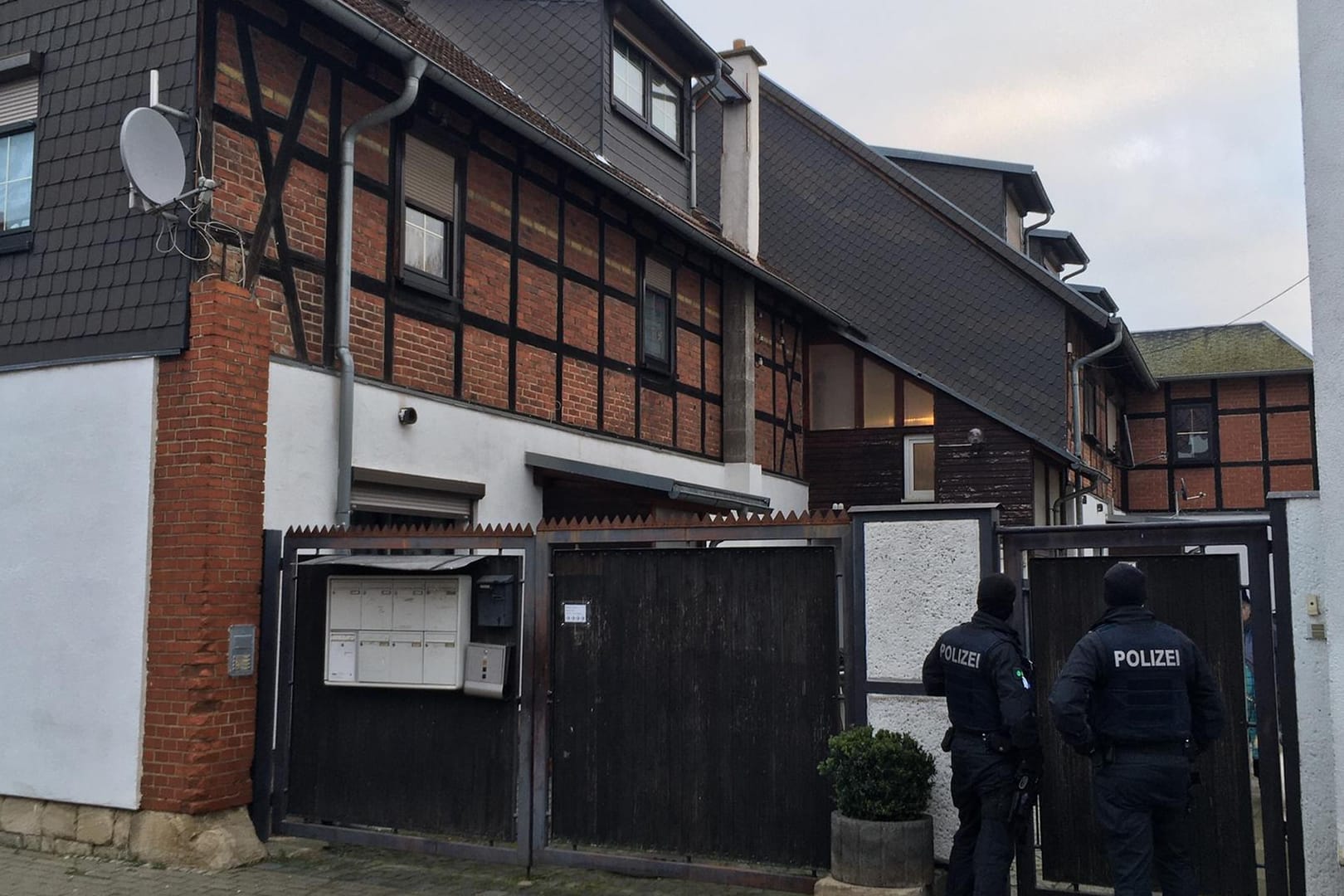 Polizisten stehen vor einem Wohnhaus in Erfurt. Neben dem Wohnhaus in Thüringen untersuchte die Polizei am Morgen weitere Objekte in insgesamt sechs Bundesländern.