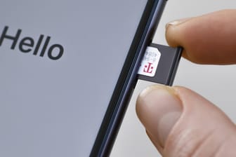 Eine SIM-Karte der Telekom wird in ein iPhone eingeschoben: Der Anbieter startet demnächst seine neuen Prepaid-Tarife.