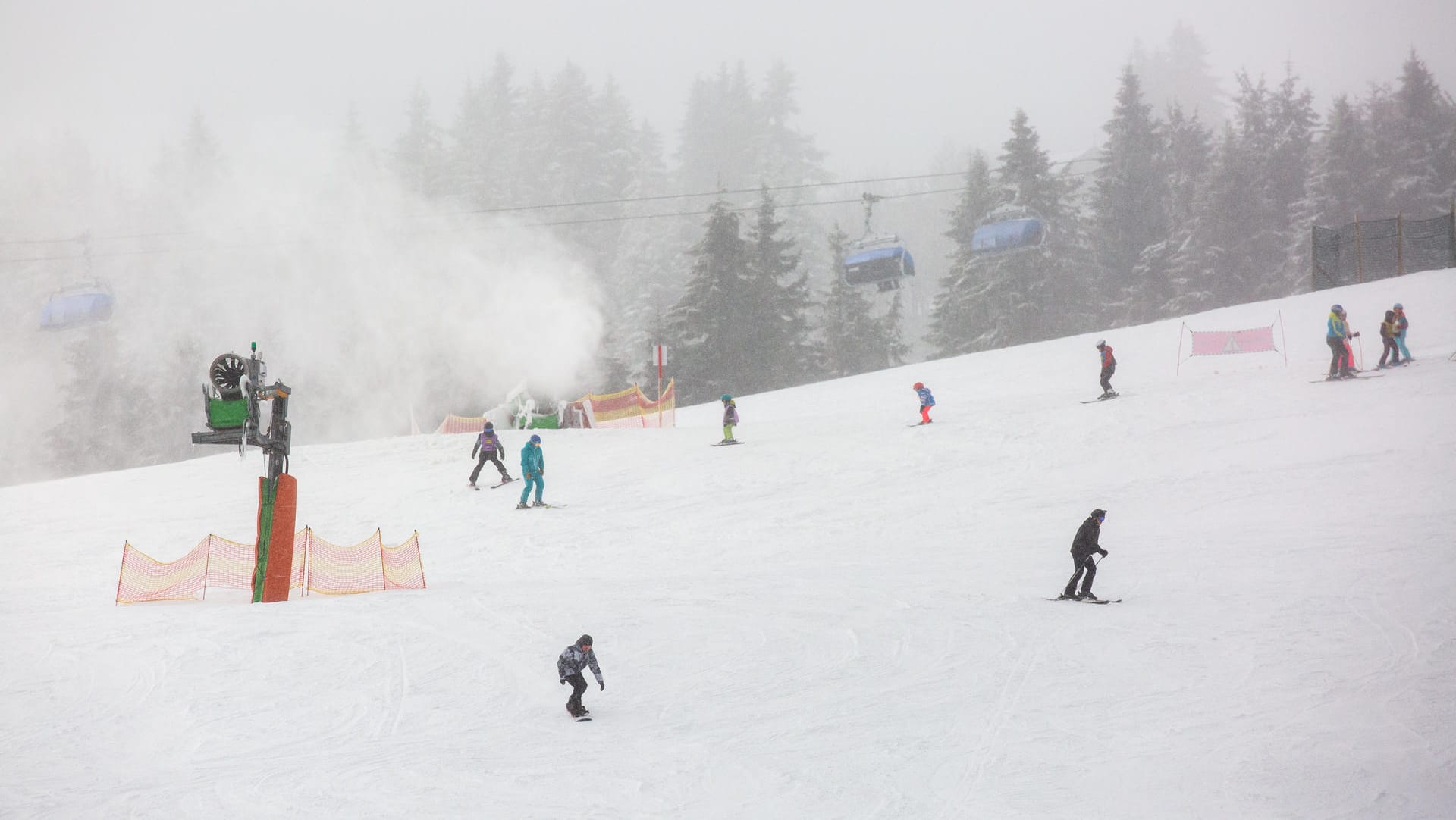 Schnee: Wintersportler fahren eine Skipiste auf dem Feldberg im Schwarzwald herunter.