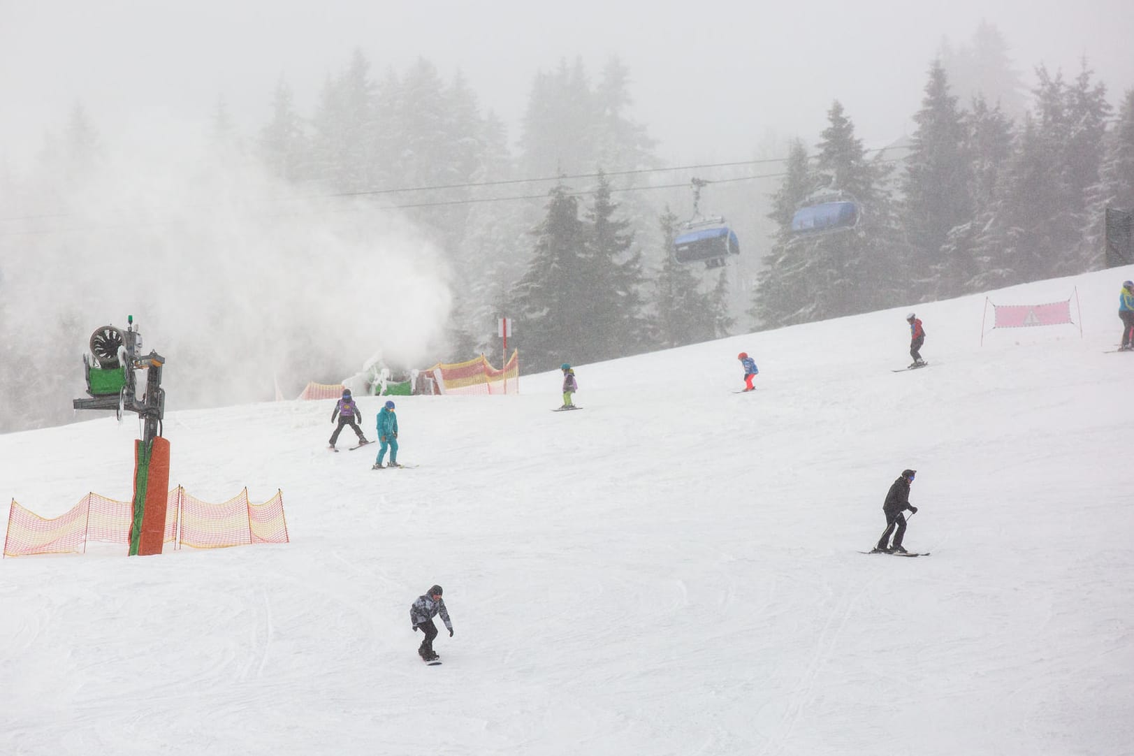 Schnee: Wintersportler fahren eine Skipiste auf dem Feldberg im Schwarzwald herunter.