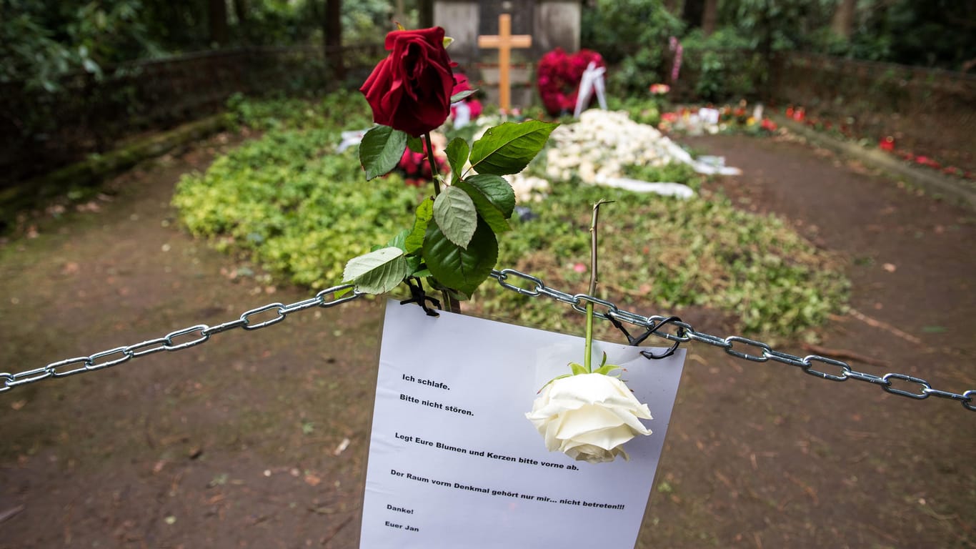 Hamburg: Blumen liegen auf der Grabstätte des Schauspielers Jan Fedder auf dem Ohlsdorfer Friehof – eine Kette dient als Abstandshalter.