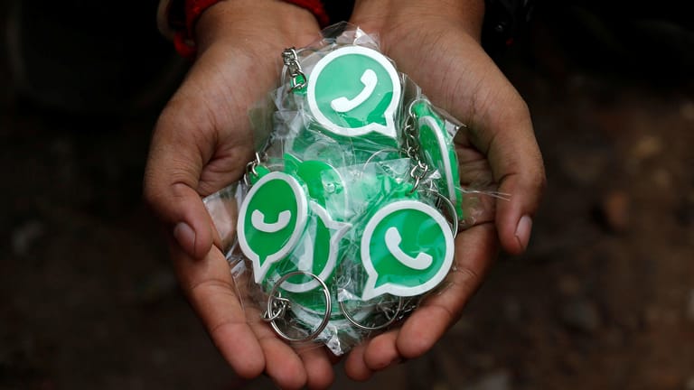 Eine Person hält Schlüsselanhänger mit WhatsApp-Logo in der Hand: Wer den Code weitergibt, verliert sein WhatsApp-Konto.