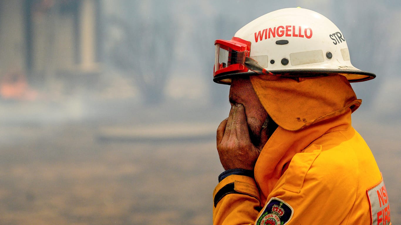 Ein Feuerwehrmann reibt seine Augen, während er einen Brand in der Nähe von Bundanoon bekämpft: Die Brände sind für die Feuerwehr eine schwere Belastung.