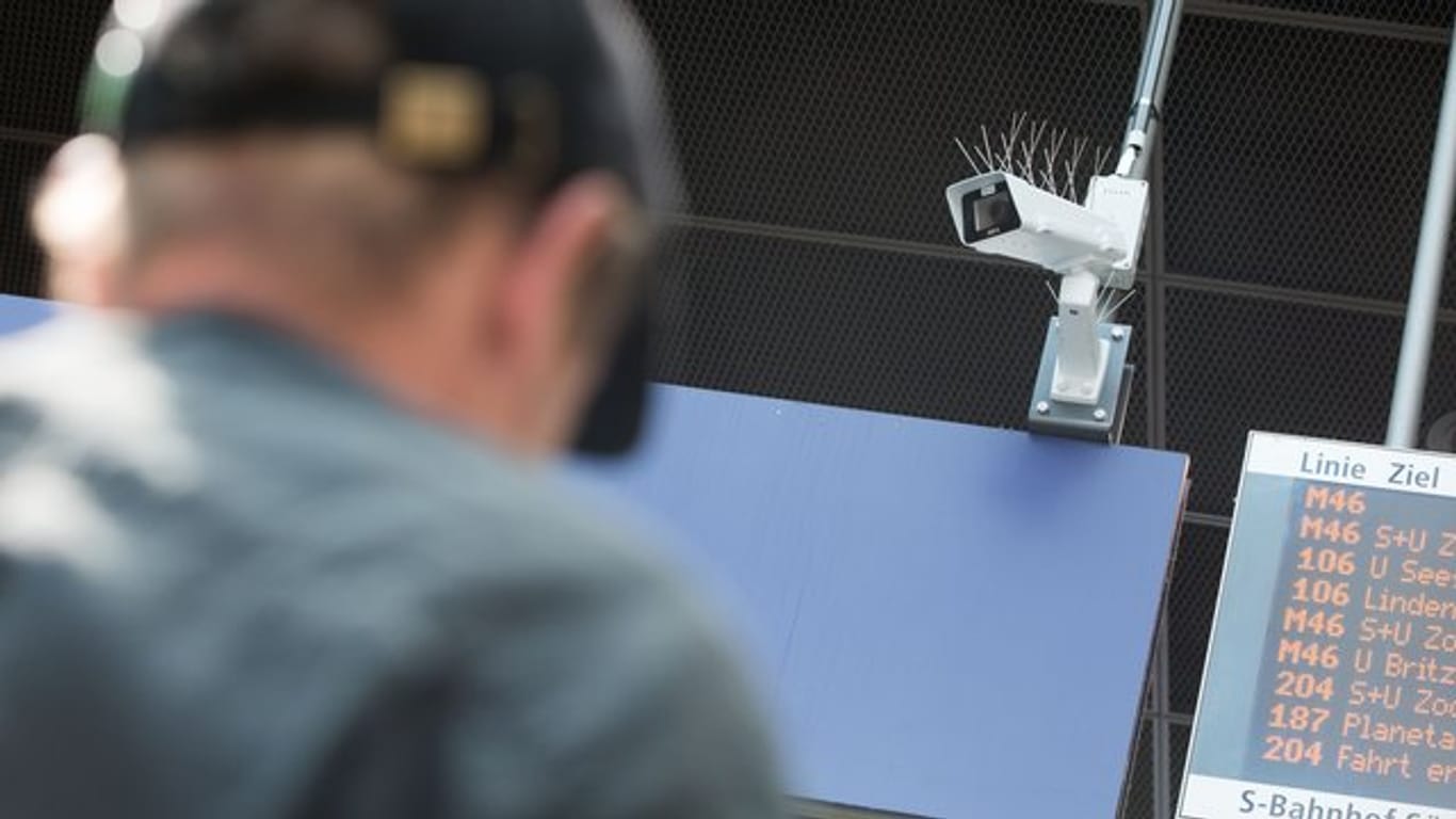 Ein Reisender steht vor einer Überwachungskamera, die während einer Testphase zur Gesichtserkennung im Bahnhof Südkreuz zu sehen ist.