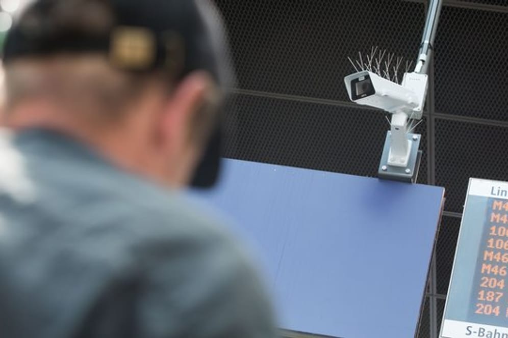 Ein Reisender steht vor einer Überwachungskamera, die während einer Testphase zur Gesichtserkennung im Bahnhof Südkreuz zu sehen ist.