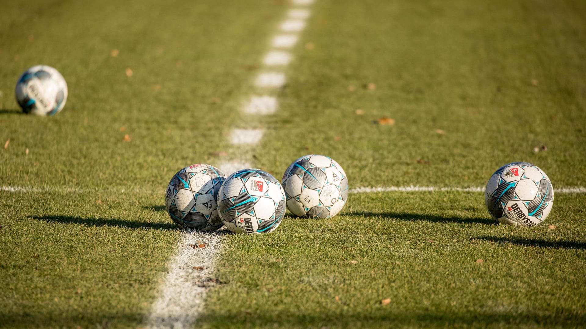 Fußbälle liegen auf dem Rasen (Symbolbild): Die Helmut-Rahn-Sportanlage in Essen könnte umgebaut werden.