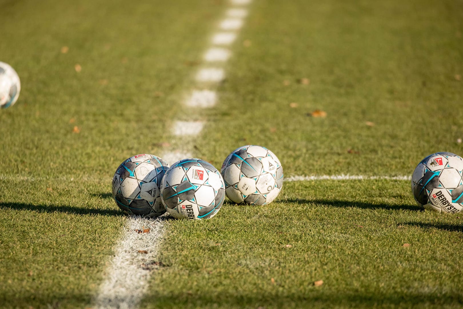 Fußbälle liegen auf dem Rasen (Symbolbild): Die Helmut-Rahn-Sportanlage in Essen könnte umgebaut werden.