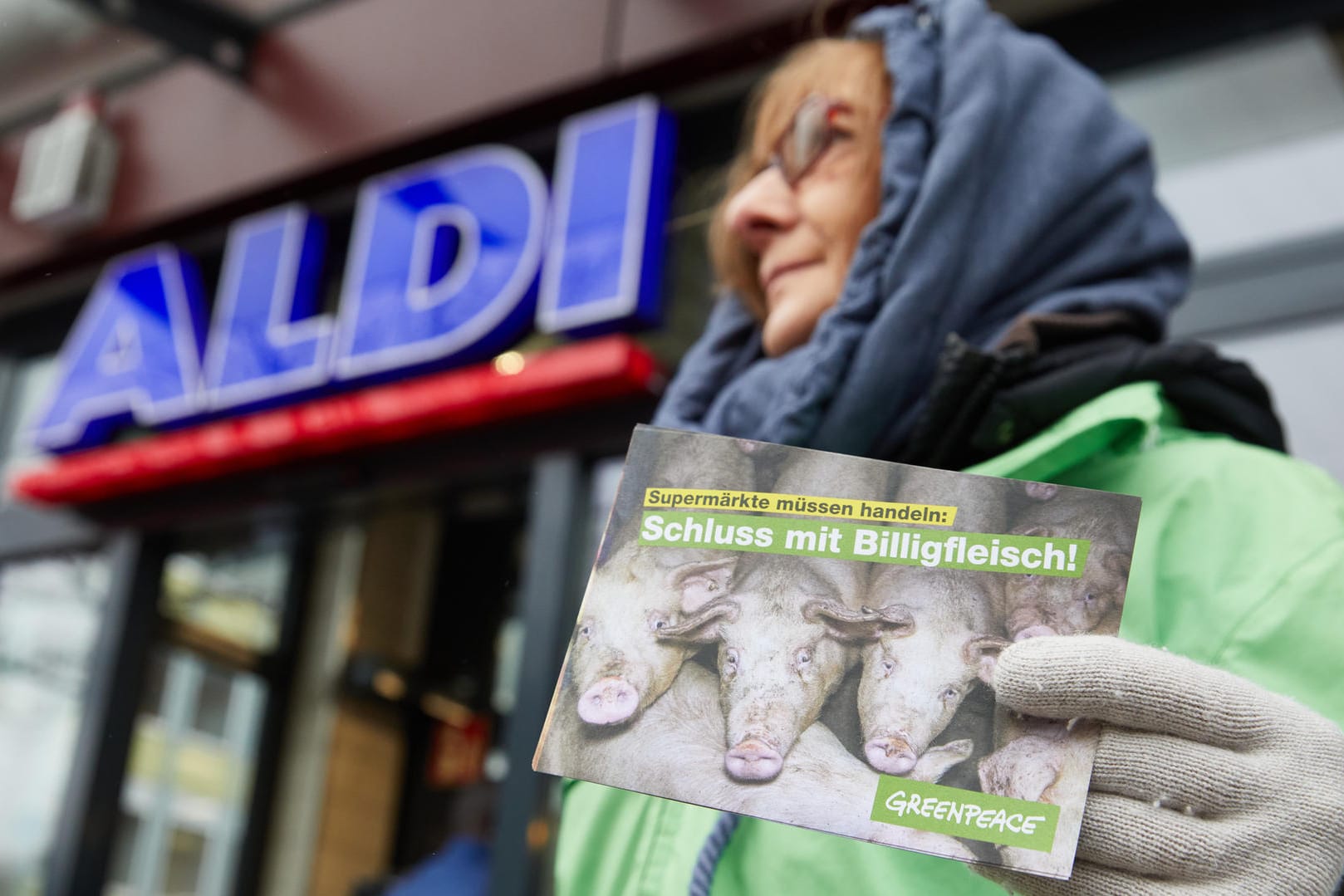 Eine Frau verteilt Flyer vor einer Aldi-Filiale in Hamburg: "Supermärkte müssen handeln: Schluss mit Billigfleisch!"