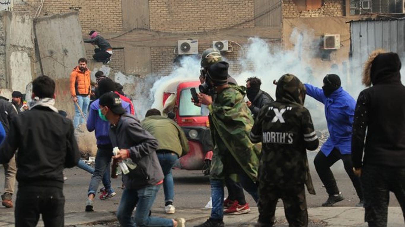 Rauch und Tränengas steigen bei Zusammenstößen zwischen Demonstranten und Sicherheitskräften in Bagdad auf.