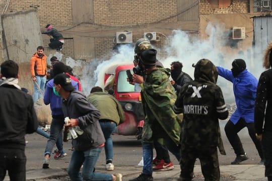 Rauch und Tränengas steigen bei Zusammenstößen zwischen Demonstranten und Sicherheitskräften in Bagdad auf.
