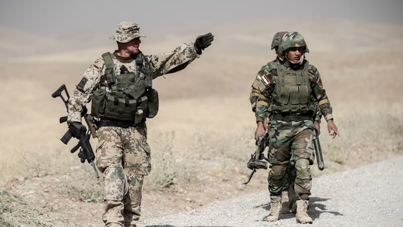 Ein Bundeswehrsoldat und Kämpfer der kurdischen Peshmerga während der Ausbildung nahe Erbil im Norden des Irak.