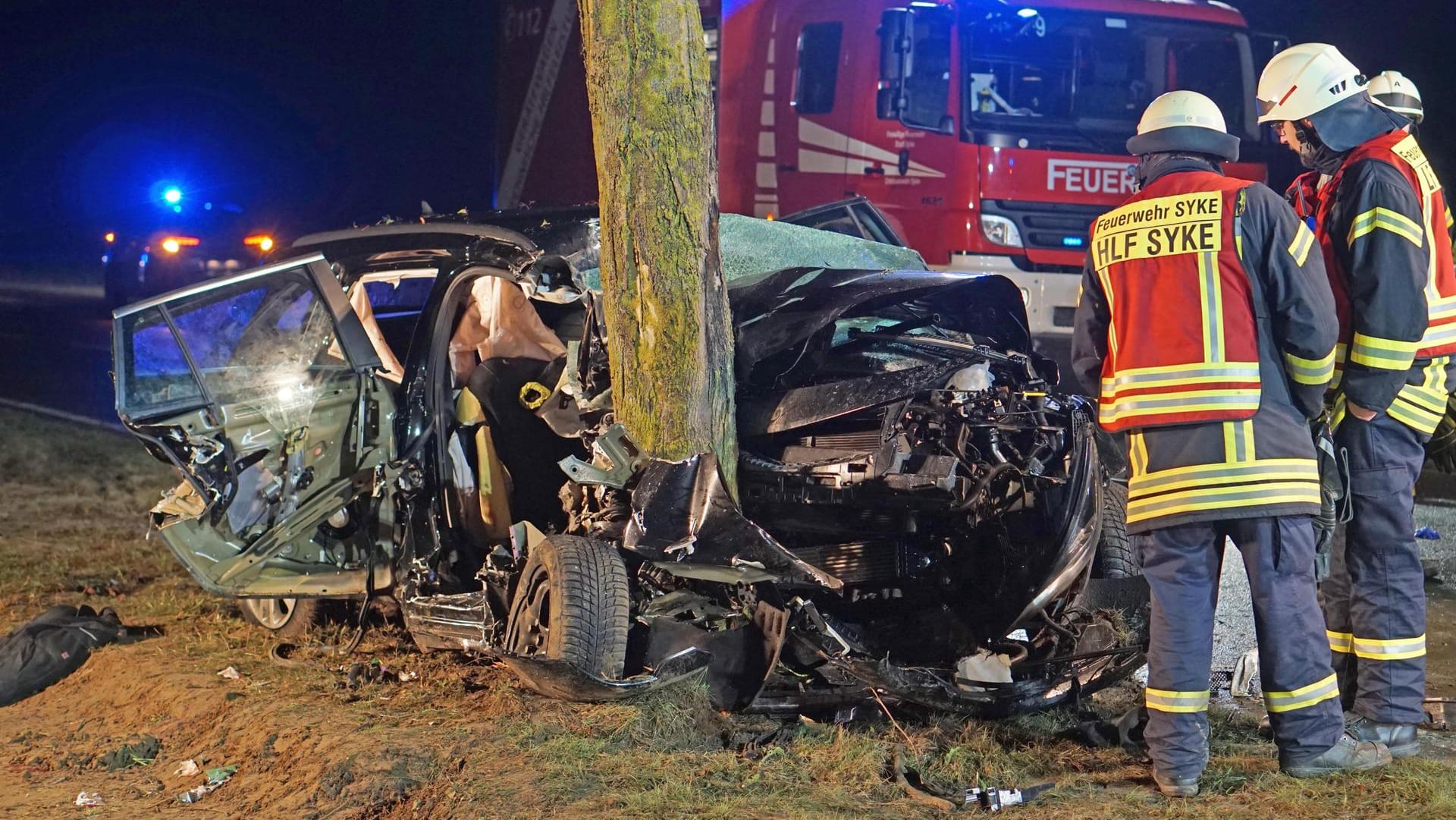 Feuerwehrleute stehen neben dem völlig zerstörten Auto: Warum der Wagen von der Straße abkam, ist völlig unklar.