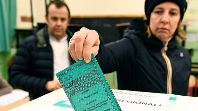 Eine Frau wirft ihren Wahlzettel ein in Ravenna: Bei der Abstimmung in der Region Emilia Romagna wird mit einem knappen Ergebnis gerechnet.