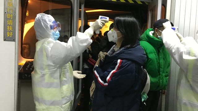 Gesundheitsbeamte kontrollieren am Flughafen von Peking die Körpertemperatur von Reisenden aus der Stadt Wuhan. Gesundheitsbeamte kontrollieren am Flughafen von Peking die Körpertemperatur von Reisenden aus der Stadt Wuhan.