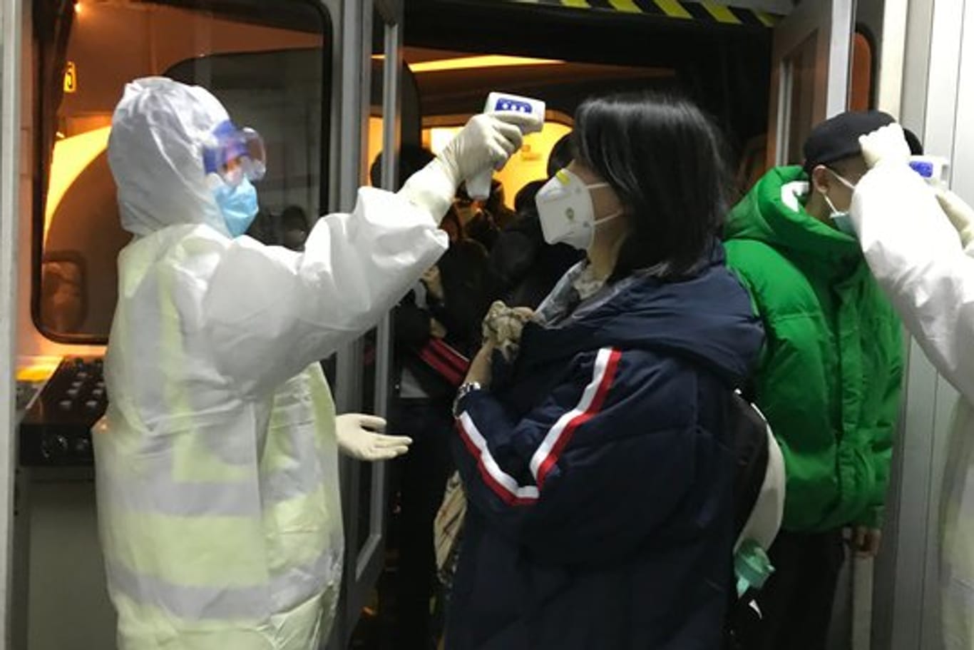 Gesundheitsbeamte kontrollieren am Flughafen von Peking die Körpertemperatur von Reisenden aus der Stadt Wuhan.