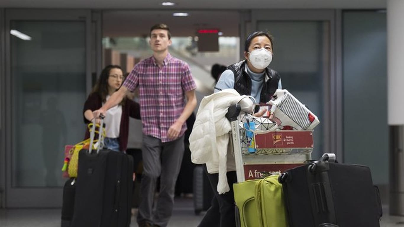 Eine Frau trägt am Toronto Pearson International Airport eine Atemschutz-Maske.