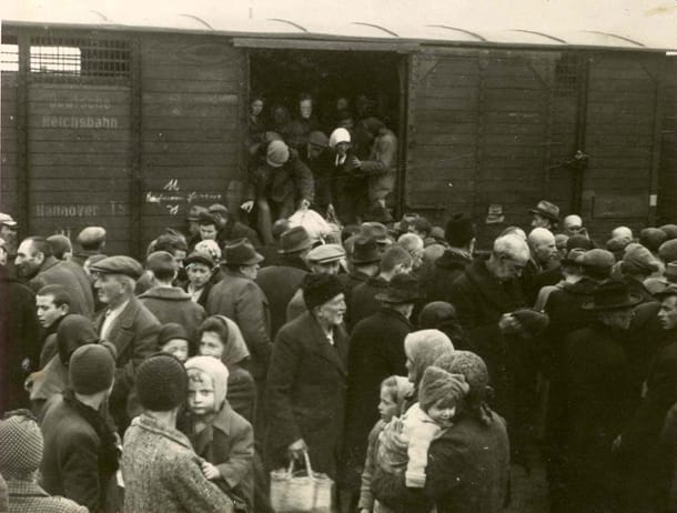 Juden steigen nach tagelanger Fahrt aus einem Waggon. An der Zugwand ist der Schriftzug "Deutsche Reichsbahn" zu erkennen.