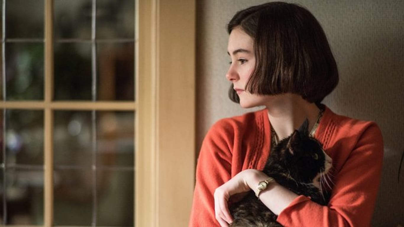 Die Schauspielerin Lea van Acken als Anne Frank mit einer Katze auf dem Arm.