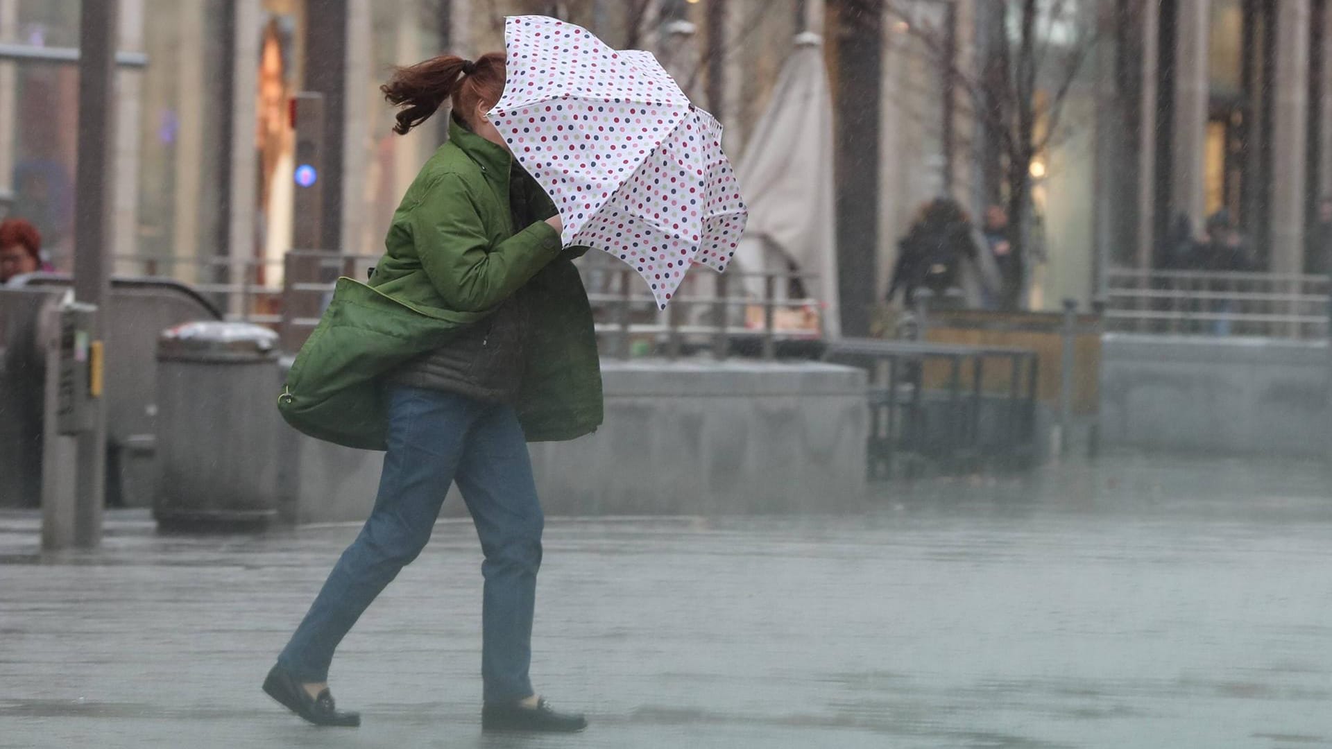 Eine Frau kämpft mit ihrem Regenschirm gegen einen heftigen Schauer: Als erstes trifft "Lolita" auf Baden-Württemberg. (Symbolbild)