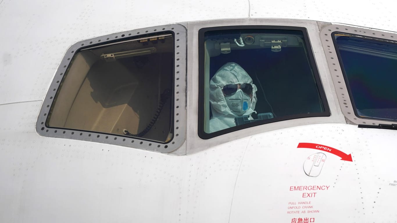 Wuhan: Ein Pilot sitzt mit Schutzanzug im Cockpit und parkt ein Flugzeug an der Entladestelle auf dem Internationalen Flughafen Wuhan-Tianhe.