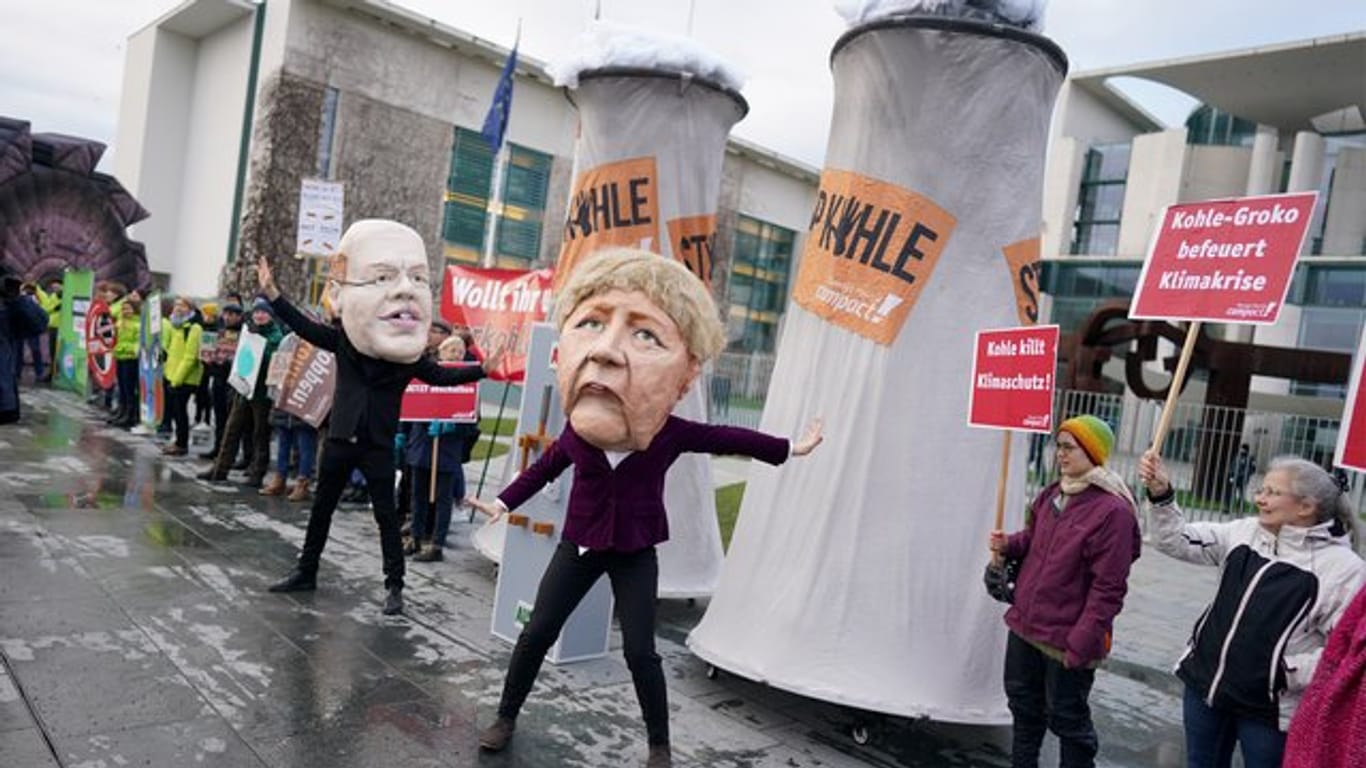 Aktivisten protestieren verkleidet als Angela Merkel und Peter Altmaier vor dem Bundeskanzleramt gegen den Zeitplan für den Kohleausstieg.