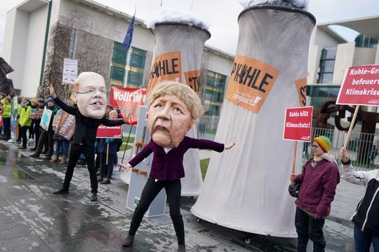 Aktivisten protestieren verkleidet als Angela Merkel und Peter Altmaier vor dem Bundeskanzleramt gegen den Zeitplan für den Kohleausstieg.