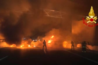 Feuerwehrleute löschen die brennende Fahrzeuge: Der Fahrer des Geldtransporters konnte flüchten.