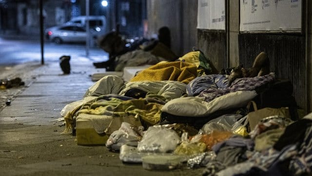 Obdachlose Menschen liegen unter einer Brücke am Bahnhof Zoo.