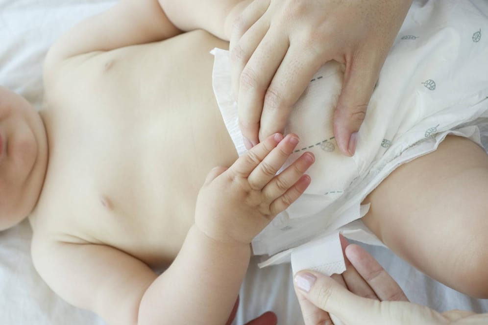 Ein Kleinkind mit Windel (Symbolbild): In den USA hat eine Erzieherin mit Filzstift auf einen Babybauch geschrieben.