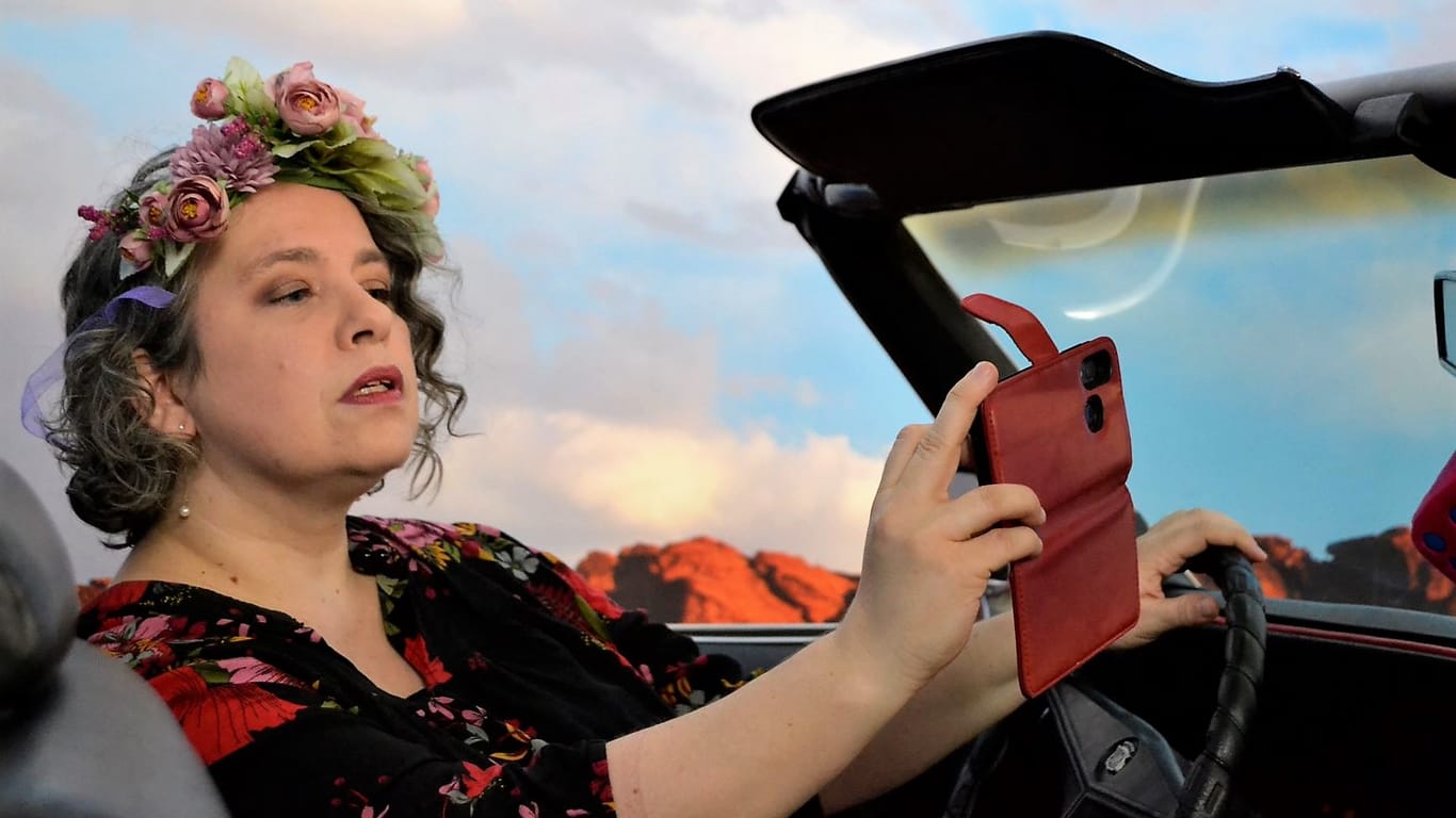 Miss Cherry Wine schießt in einem Auto ein Selfie.
