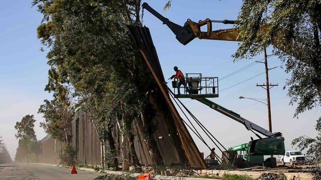 Vom Winde verweht: Bauarbeiter arbeiten an der Reparatur des Grenzzauns zwischen Mexiko und den USA. Vom Winde verweht: Bauarbeiter arbeiten an der Reparatur des Grenzzauns zwischen Mexiko und den USA.