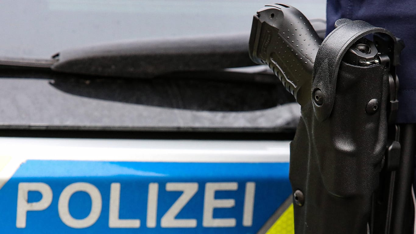 Ein Polizist mit Waffe steht vor einem Einsatzfahrzeug: Aus Viernheim floh der Verdächtige ins benachbarte Mannheim, wo er schließlich gestellt wurde (Symbolbild).
