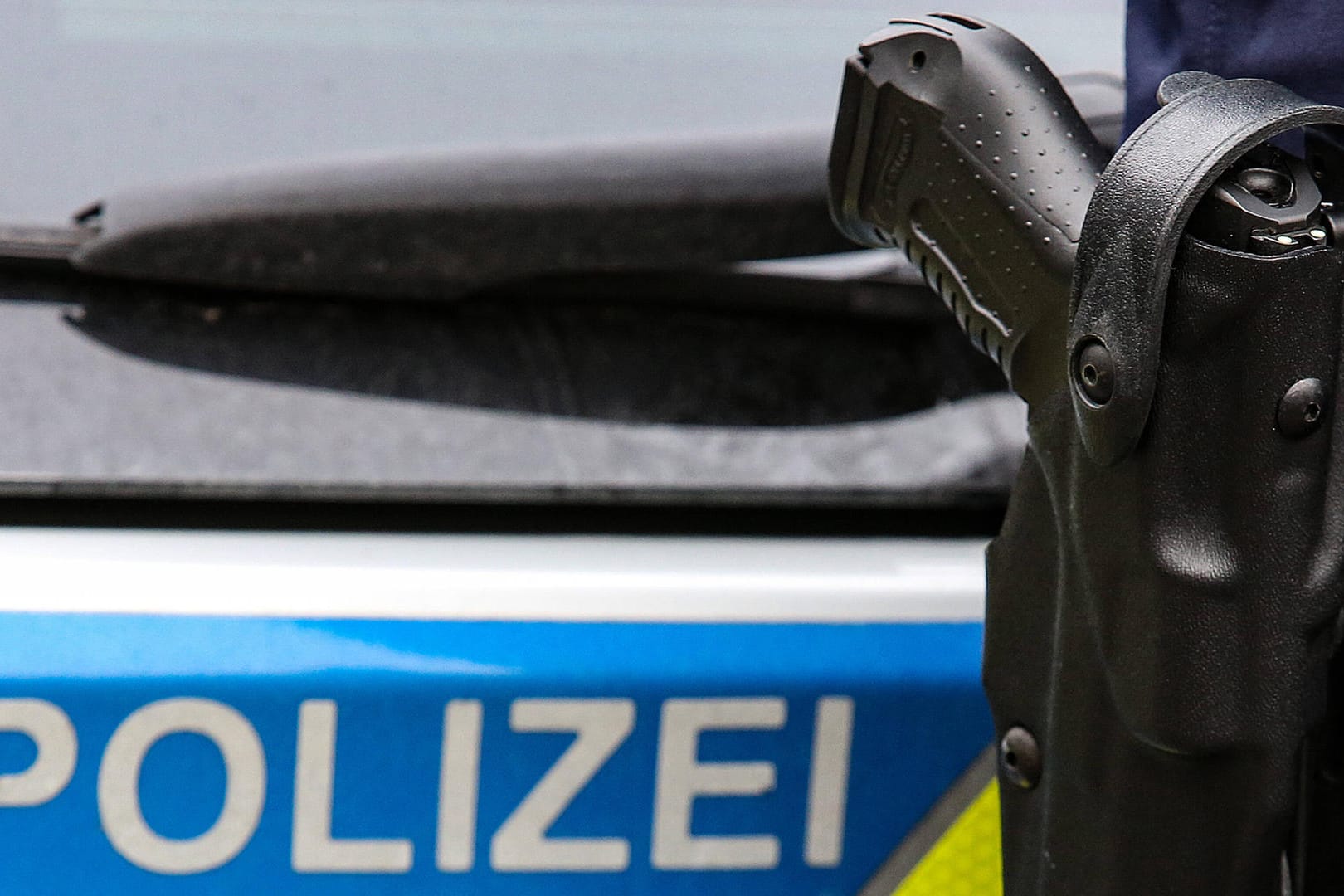 Ein Polizist mit Waffe steht vor einem Einsatzfahrzeug: Aus Viernheim floh der Verdächtige ins benachbarte Mannheim, wo er schließlich gestellt wurde (Symbolbild).