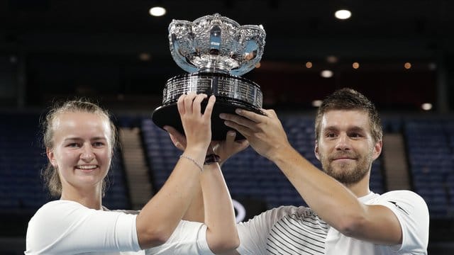 Die Tschechin Barbora Krejcikova und der Kroate Nikola Mektic halten nach ihrem Sieg den Pokal in die Höhe.