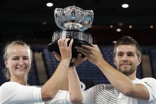 Die Tschechin Barbora Krejcikova und der Kroate Nikola Mektic halten nach ihrem Sieg den Pokal in die Höhe.