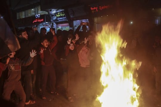 Palästinensische Kinder versammeln sich um brennende Reifen bei einem Protest im Flüchtlingslager Jabalia im nördlichen Gazastreifen gegen den Nahost-Plan von US-Präsident Trump.