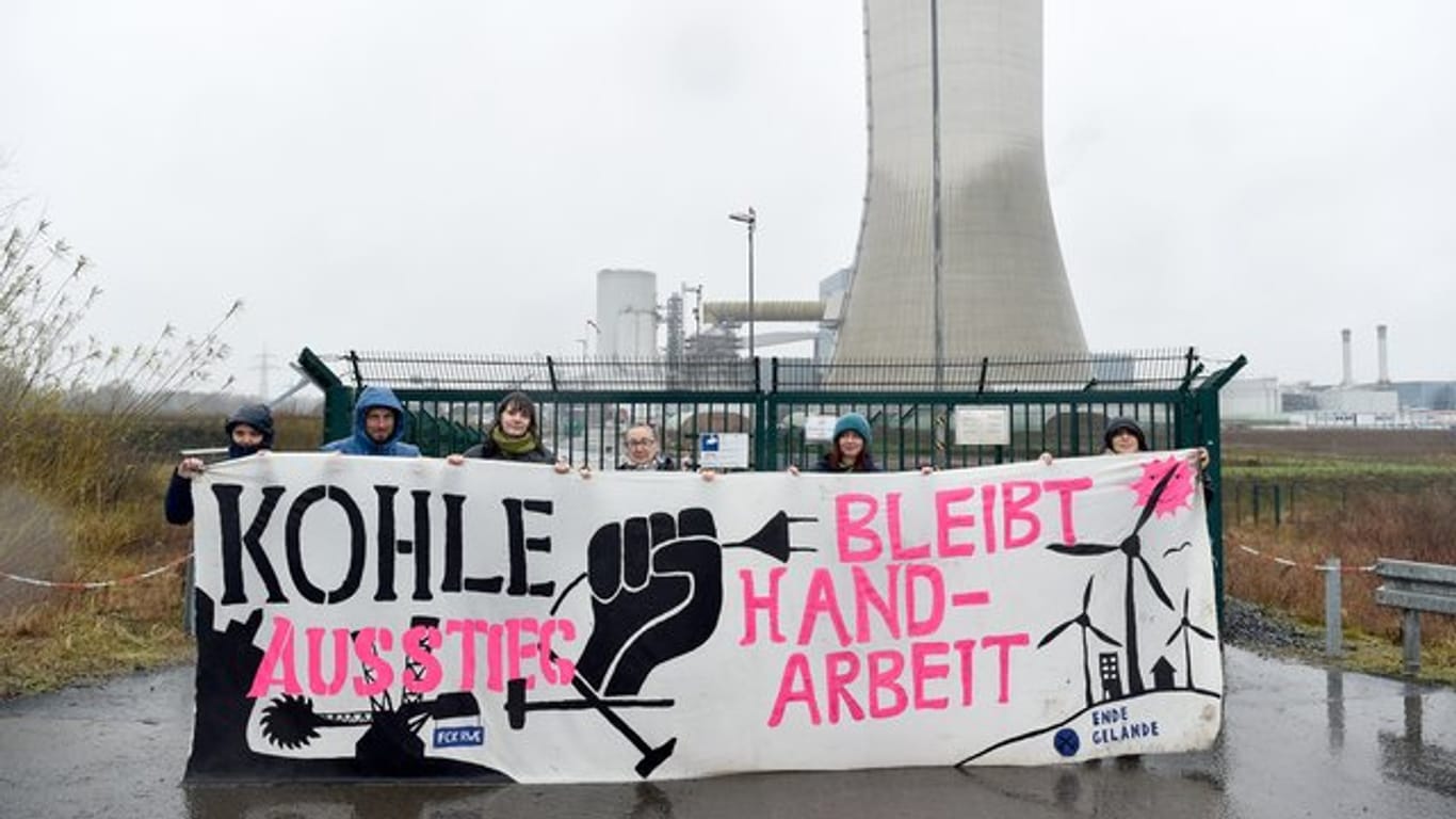 Aktivisten stehen mit einem Transparent vor dem Kraftwerk in Datteln.