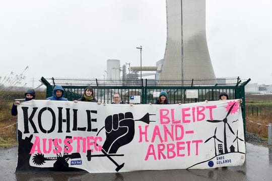 Aktivisten stehen mit einem Transparent vor dem Kraftwerk in Datteln.