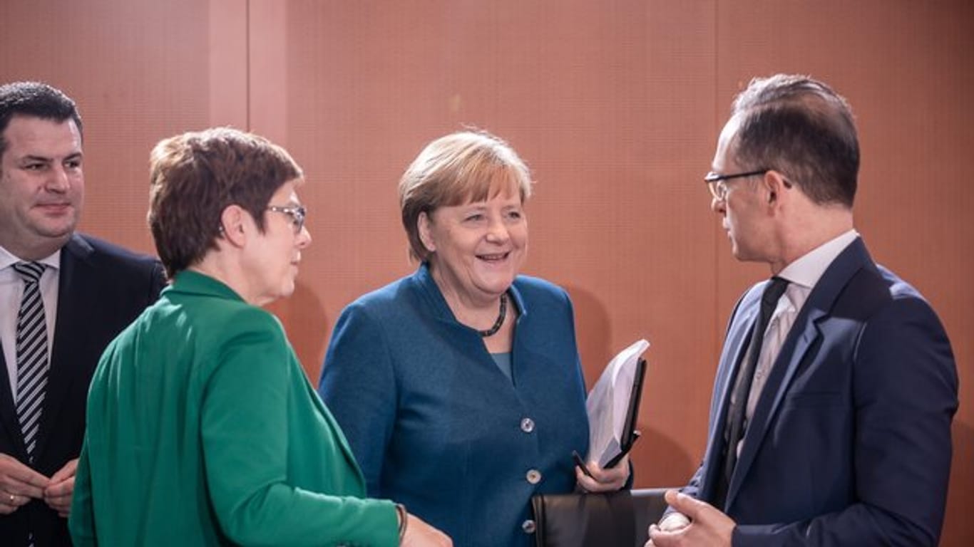 Bundeskanzlerin Angela Merkel (CDU) spricht mit Heiko Maas (SPD, r), Außenminister, zu Beginn der Sitzung des Bundeskabinetts im Kanzleramt während daneben Annegret Kramp-Karrenbauer (CDU, 2.