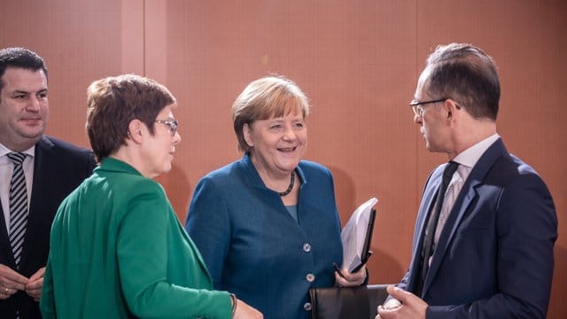 Bundeskanzlerin Angela Merkel (CDU) spricht mit Heiko Maas (SPD, r), Außenminister, zu Beginn der Sitzung des Bundeskabinetts im Kanzleramt während daneben Annegret Kramp-Karrenbauer (CDU, 2. Bundeskanzlerin Angela Merkel (CDU) spricht mit Heiko Maas (SPD, r), Außenminister, zu Beginn der Sitzung des Bundeskabinetts im Kanzleramt während daneben Annegret Kramp-Karrenbauer (CDU, 2.
