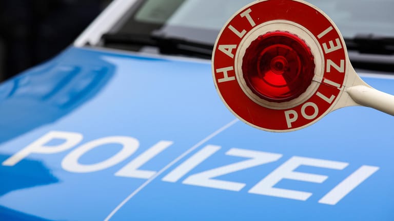 Einsatzfahrzeug und Polizeikelle (Symbolbild): Die Polizei sucht nach Zeugen.