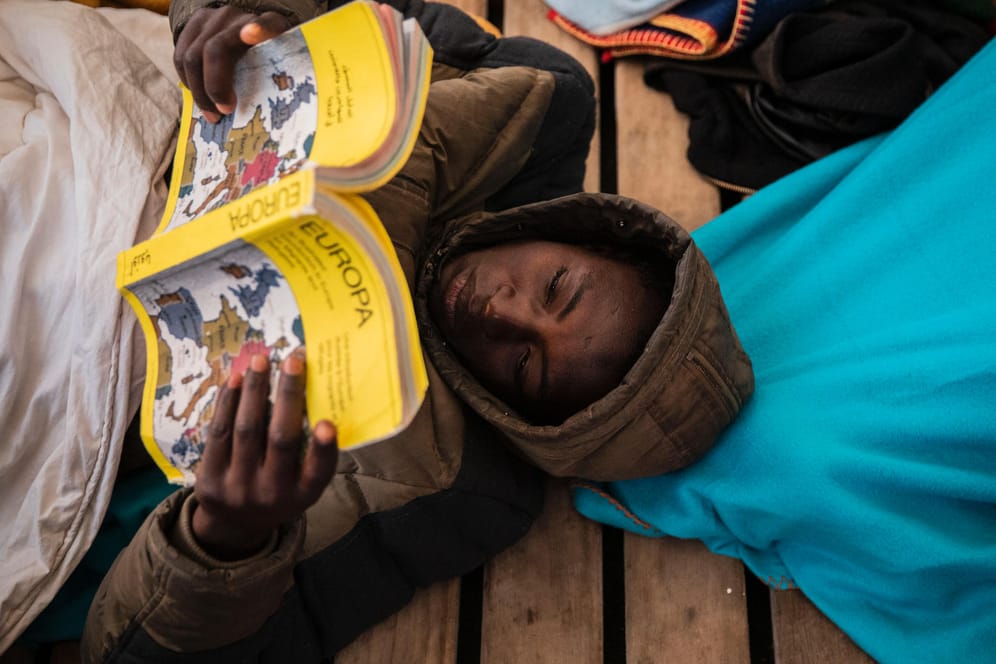 Gauro, 15, aus Mali, liest an Bord des Rettungsschiffes "Open Arms" ein Buch über Europa: Die Migranten mussten mehrere Tage auf die Genehmigung zum Einlaufen der "Open Arms" warten.